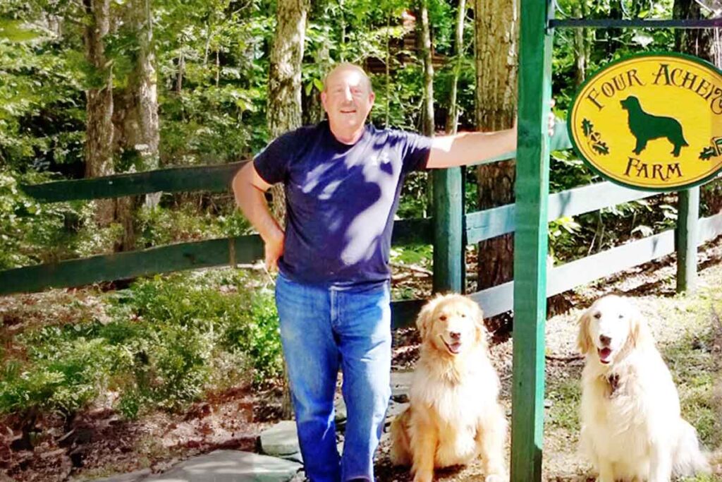 Barry, an esophageal cancer survivor, standing with two dogs outdoors