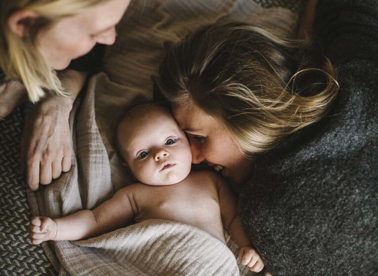 Moms in bed with newborn baby