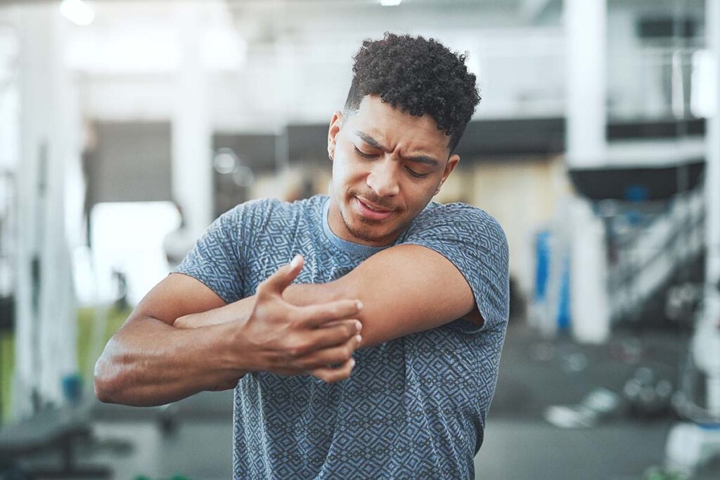 a man holds his sore arm