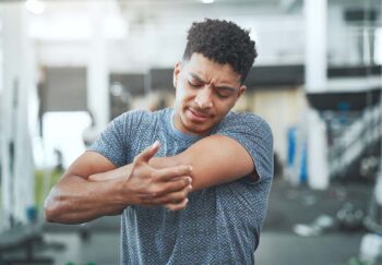 a man holds his sore arm