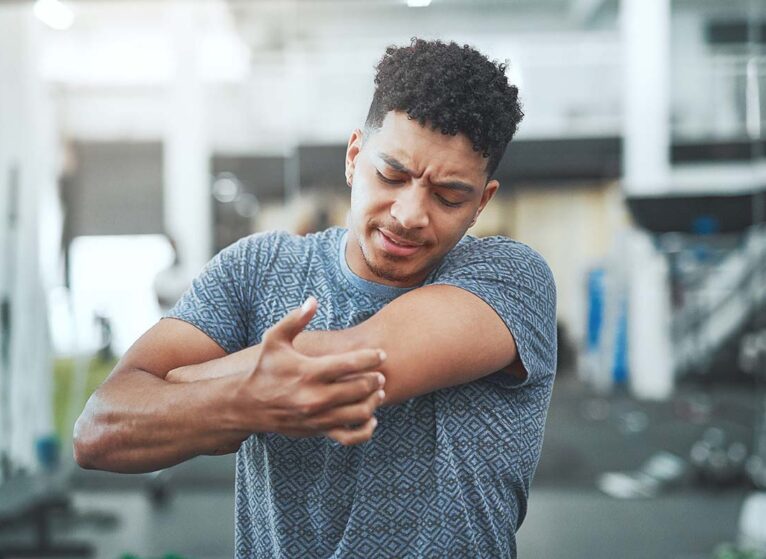 a man holds his sore arm