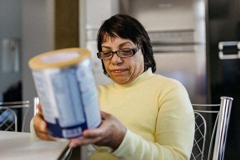 Woman reading a label from a food can