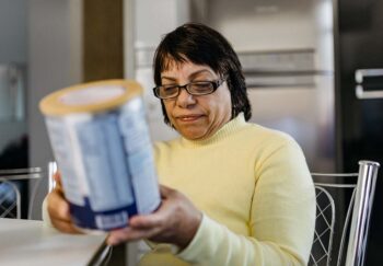 Woman reading a label from a food can