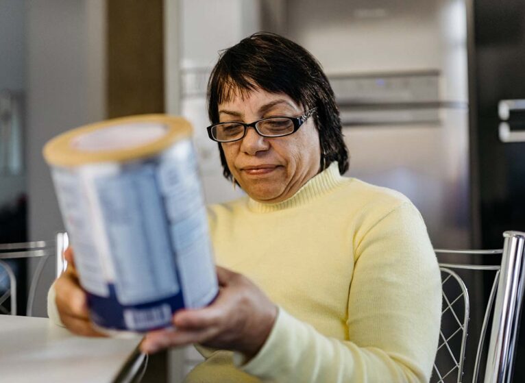 Woman reading a label from a food can