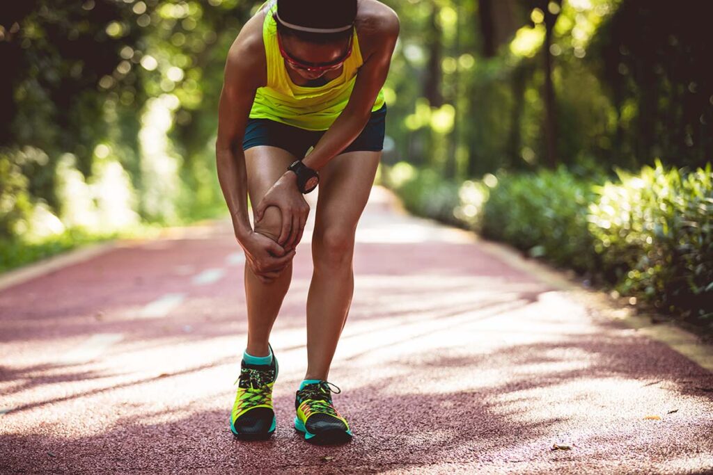 a runner stops and grabs her leg