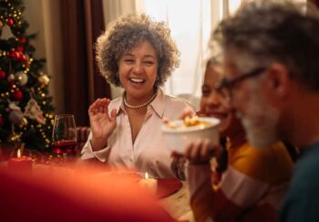 A woman smiling to her family at the table during a holiday get-together