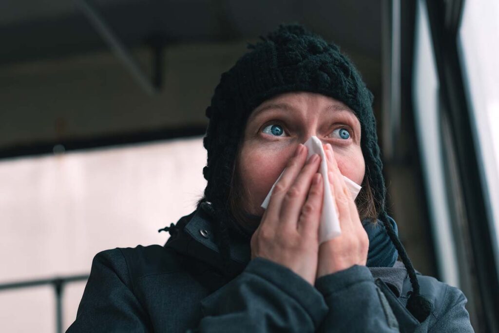 Woman blowing her nose into paper handkerchief on the bus on a cold winter day, is it a cf leak?