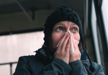 Woman blowing her nose into paper handkerchief on the bus on a cold winter day, is it a cf leak?