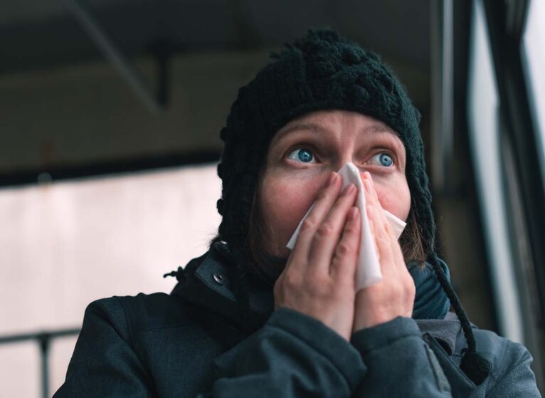 Woman blowing her nose into paper handkerchief on the bus on a cold winter day, is it a cf leak?