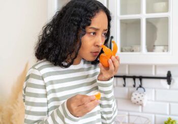 A woman smells an orange