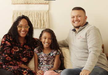 Faith sits between her two parents on the couch