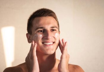 A man applies sunscreen to his face