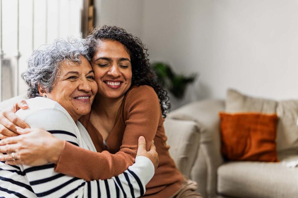 And older and younger woman hug
