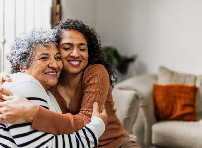 And older and younger woman hug