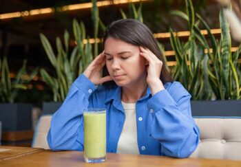 Know the anorexia heart failure signs before things get worse. A girl stares at a green smoothie with worry.