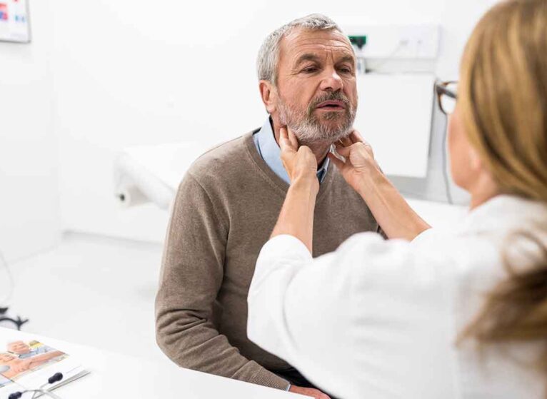 A middle-aged man gets his throat examined. HIs GERD could be a sign of esophageal cancer.