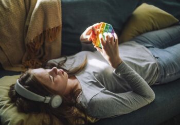 Teenage girl listens to music and plays with fidget toy