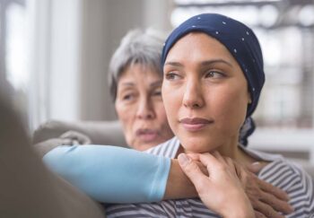 A woman comforts another woman with breast cancer