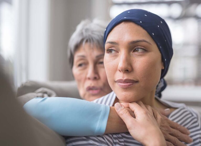 A woman comforts another woman with breast cancer