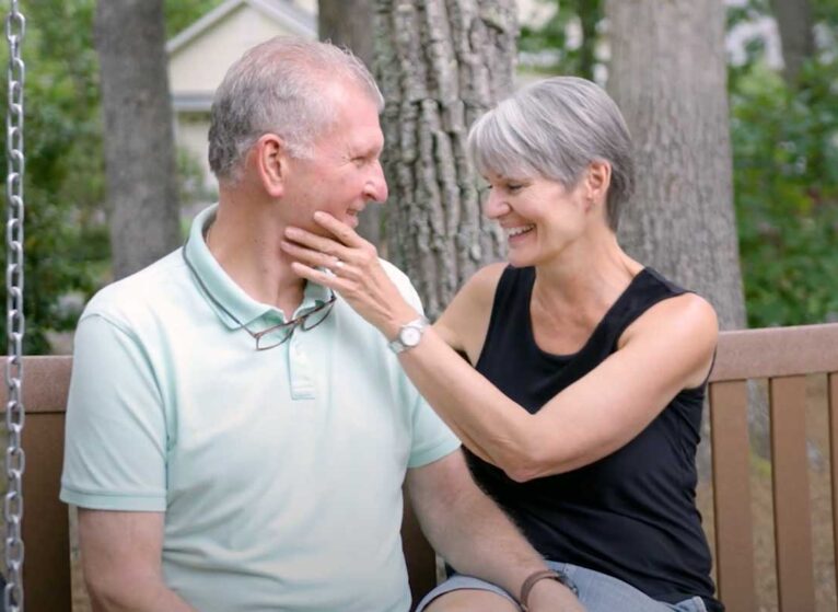 Aquablation patient David sit with his wife on a swing, happy after the procedure